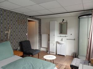 a bedroom with a bed and a chair and a sink at B&B aan het water in Earnewâld +77 photos