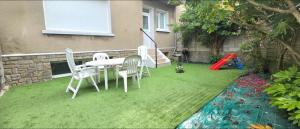 a lawn with a table and chairs and a playground at Escapade Bord de Mer - Terrasse & Parking privé, Plage à 300 m in Le Portel