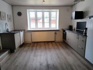 an empty kitchen with a large window in a room at Henne Station, Midtiby B & B in Henne