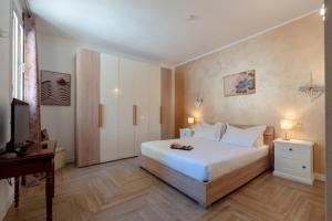 a bedroom with a white bed and a television at Gold Apartment in Ferrara