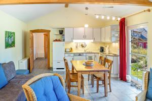 a kitchen and dining room with a table and chairs at Bungalow am Haussee in Himmelpfort