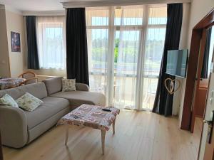 a living room with a couch and a tv at alma713 apartman in Zalakaros