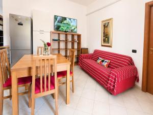 a living room with a red couch and a table at Casa Are in Oristano