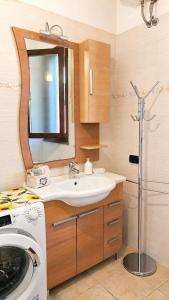 a bathroom with a sink and a washing machine at Casa Are in Oristano +46 photos