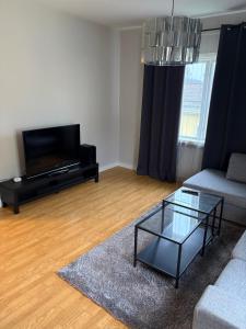 a living room with a couch and a glass coffee table at Two rooms and kitchen in central Uddevalla in Uddevalla +3 photos
