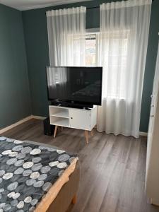 a living room with a flat screen tv on a dresser at Two rooms and kitchen in central Uddevalla in Uddevalla