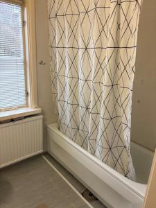 a shower curtain in a bathroom with a tub at Two rooms and kitchen in central Uddevalla in Uddevalla