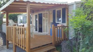 a wooden deck with a pergola on a house at Mobilhome Rico in Gassin