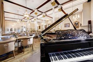 a room with a piano and tables and chairs at Hotel Lomnica in Tatranská Lomnica +47 photos