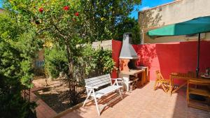 a patio with a bench and an outdoor fireplace at Casa Are in Oristano