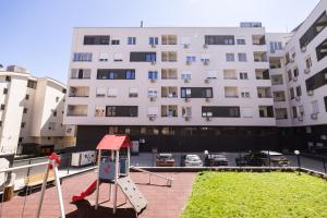 a playground in front of a large building at Liman 5 Riverside 209 i 109 with Free Private Parking in Novi Sad