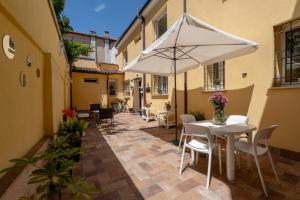 a patio with a white table and an umbrella at Gold Apartment in Ferrara