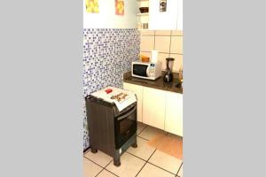 a small kitchen with a microwave and a stove at Iracema Apartament in Fortaleza