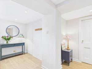 a white room with a blue dresser and a mirror at Laura's House in Coupar Angus