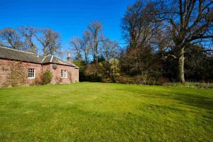an old brick house with a large grass yard at Laura's House in Coupar Angus