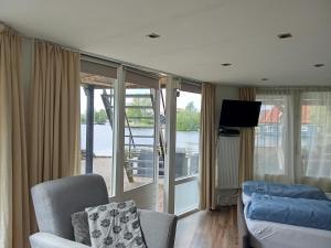 a living room with a couch and a tv at B&B aan het water in Earnewâld