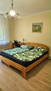 a bedroom with a large bed with a wooden frame at Balatoni HUNOR Vendégház in Balatonvilágos