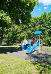 a playground with a slide in a park at Balatoni HUNOR Vendégház in Balatonvilágos