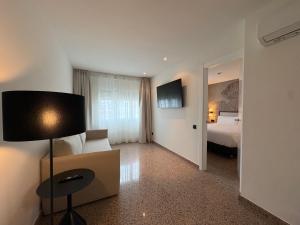 a hotel room with a bed and a lamp at URH Ciutat de Mataró in Mataró