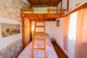 a bedroom with a bunk bed and a ladder at Vikendica,Bungalovi Lipska pećina in Cetinje