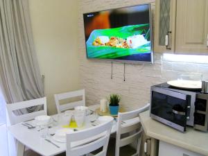 スヴェトロゴルスクにあるApartments Malina Park 2のキッチン(テーブル付)、壁掛けテレビ