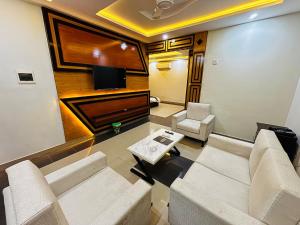 a living room with a couch and a table at Sapphire Stays Hotel And Restaurant in Peshawar
