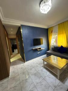 a living room with a couch and a tv at Apparemment TAMARIS in Dar Bouazza
