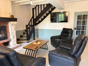 a living room with leather furniture and a fireplace at Gîte des Tilleuls - Nature, calme, télétravail - Animaux acceptés in Graçay