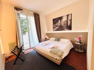 a bedroom with a bed and a large window at Private Terrace Cozy Flat near Vicenza Center in Vicenza