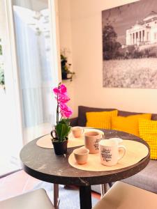 a table with coffee cups and a flower on it at Private Terrace Cozy Flat near Vicenza Center in Vicenza +14 photos