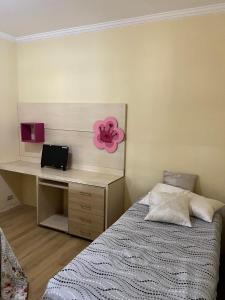 a bedroom with a bed and a desk with a laptop at Chácara com Piscina in Poços de Caldas +28 photos