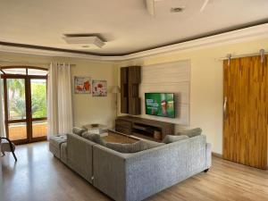 a living room with a couch and a television at Chácara com Piscina in Poços de Caldas