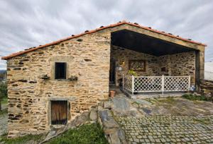 an old stone house with a large doorway at Casas de Xisto in Mogadouro