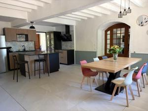 a kitchen and dining room with a wooden table and chairs at Gîte des Tilleuls - Nature, calme, télétravail - Animaux acceptés in Graçay