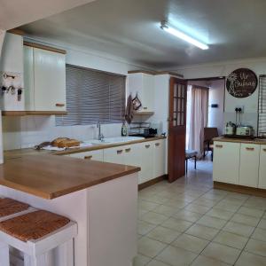 a kitchen with white cabinets and a counter top at Vir Oulaas Guesthouse in Nieuwoudtville