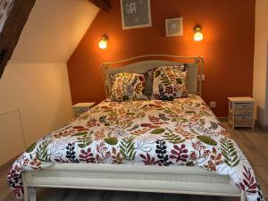 a bed in a bedroom with orange walls at Gîte des Tilleuls - Nature, calme, télétravail - Animaux acceptés in Graçay