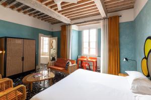 a bedroom with a bed and a living room at Le Cloître in Arles