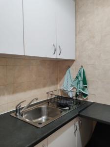 a kitchen counter with a sink and white cabinets at Danlavie in Tyger Valley