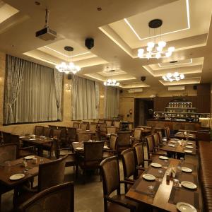 a restaurant with wooden tables and chairs in a room at Hotel Rock Regency Mount Abu - A Boutique Rodetel in Mount Ābu