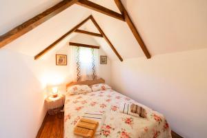 a small bedroom with a bed in a attic at Vikendica,Bungalovi Lipska pećina in Cetinje