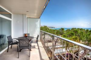 a balcony with a table and chairs and the ocean at Seafront apartment in Platja d'Aro with parking in Platja d'Aro