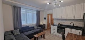 a living room with a blue couch and a kitchen at Old town luxury apartment in Braşov