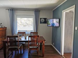 a dining room with a table and chairs and a window at Villa Orreforshult in Orrefors