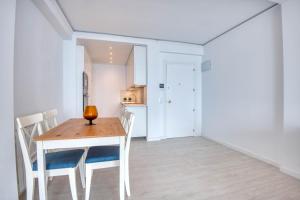 a kitchen and dining room with a wooden table and chairs at Seafront apartment in Platja d'Aro with parking in Platja d'Aro