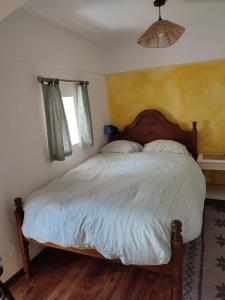 a bedroom with a large bed with a wooden headboard at Bota Rota Pilgrim House in Paredes de Coura