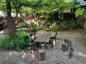 a wooden picnic table and chairs in a garden at Bota Rota Pilgrim House in Paredes de Coura