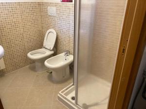 a bathroom with a toilet and a sink and a shower at Le Persiane Azzurre ovest in Albiano +21 photos