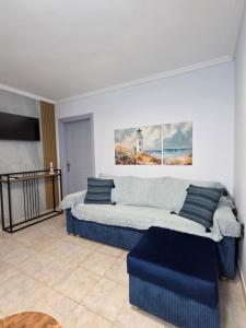 ein Wohnzimmer mit einer blauen Couch und einem Fernseher in der Unterkunft Lighthouse in Flogita