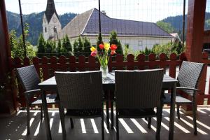 a table with chairs and a vase of flowers at Apartment Alana in Podvelka