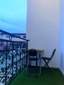 a table and two chairs on a balcony at Meublé de toursime L'Escale in Yaoundé